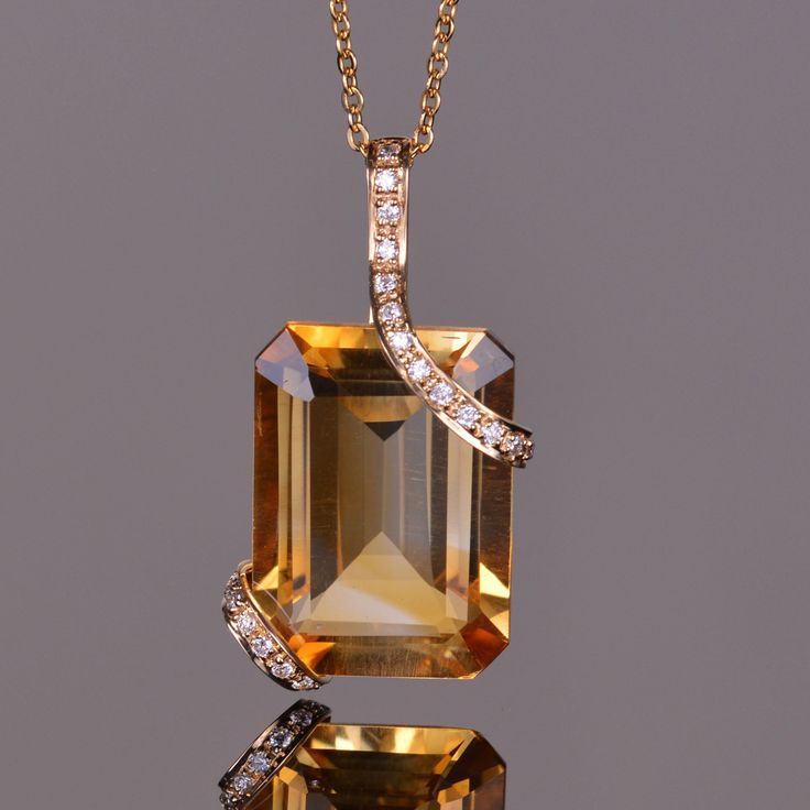 The pendant features a vibrant emerald cut 13.23 carat golden citrine. The gemstone is set within double strap sets of 14k yellow gold accented with white diamonds. This elegant pendant measures at 27.06mm x 13.74mm. Luxury Gemstone Jewelry, Luxury Citrine Jewelry With Diamond Accents, Luxury Citrine Octagon Jewelry, Luxury Octagon Citrine Jewelry, Elegant Orange Emerald Cut Jewelry, Elegant Orange Jewelry With Diamond Accents, Necklace Pendant Ideas, Women Clothes Outfits, Citrine Jewelry