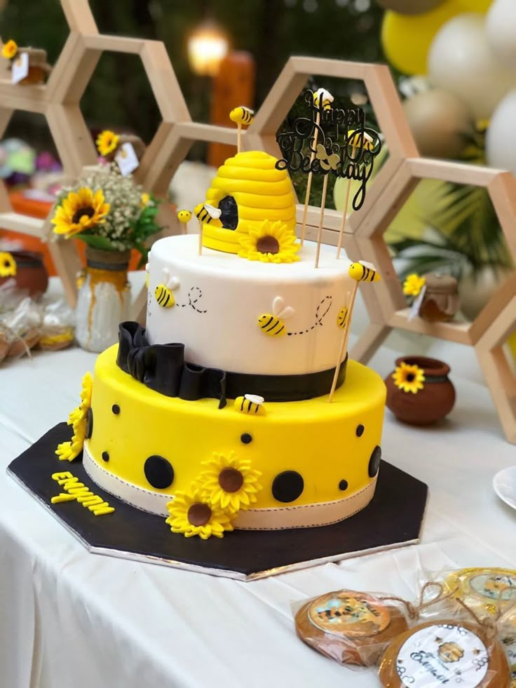 a yellow and white cake sitting on top of a table next to honeycombs