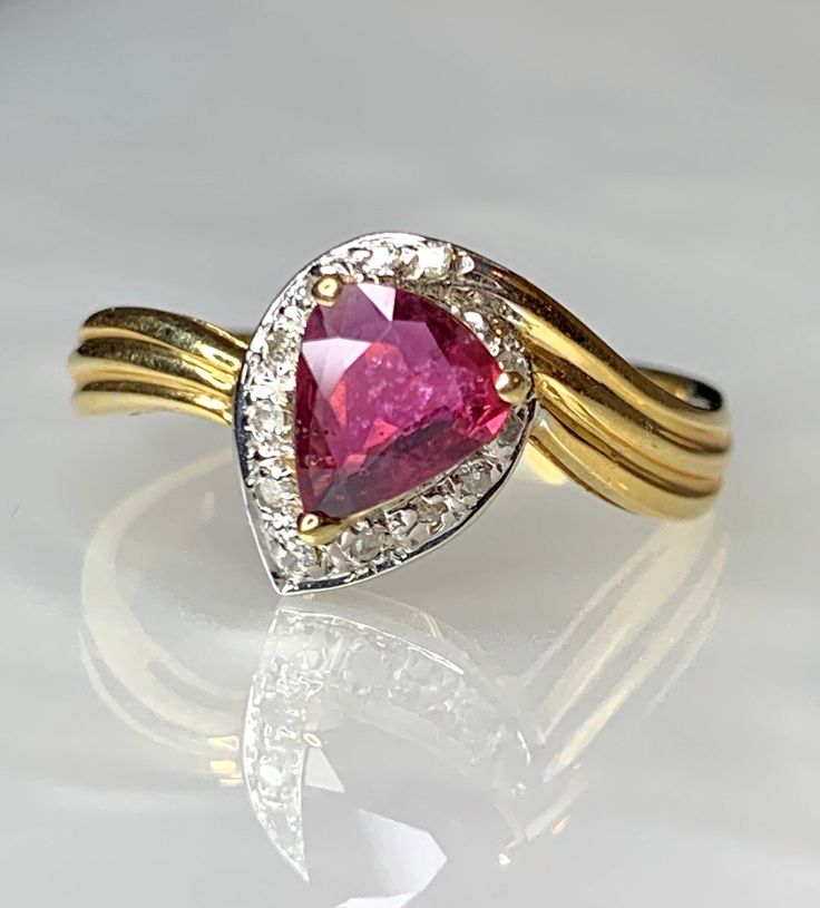 Ruby Ring, Ruby Rings For Women, Ruby Ring Vintage, Trillion Ruby Ring, Vintage Ruby Ring, Vintage Ruby Jewelry, Ruby Gold Ring, OOAK Ring A 90s style vintage bypass ring featuring a red trilliant cut ruby weighing 0.57 carats encrusted in 0.07 carats of sparkling white diamonds set in solid 14k yellow gold. * Ring size: US 7.5 * Complimentary resizing is available up to 3 sizes larger or smaller than stated size. Trillion Cut Halo Ring For Formal Occasions, Trillion Cut Halo Setting Ring For Formal Occasions, Formal Trillion Cut Ring With Halo Setting, Ruby Rings With Halo Setting For Promise, Fine Jewelry Yellow Gold Trillion Cut Ring, Pear-shaped Diamond Accented Promise Ring, Pear-shaped Promise Ring With Diamond Accents, Trillion Cut Rings With Diamond Accents For Formal Occasions, Ruby Rings With Diamond Accents