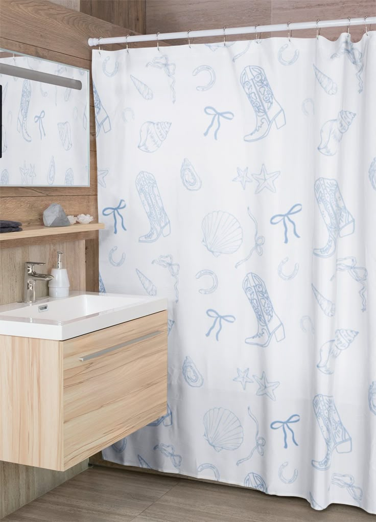 a bathroom with a sink, mirror and shower curtain that has seashells on it