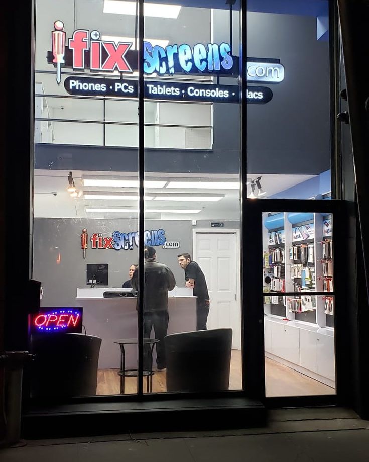 two men standing in front of a store window