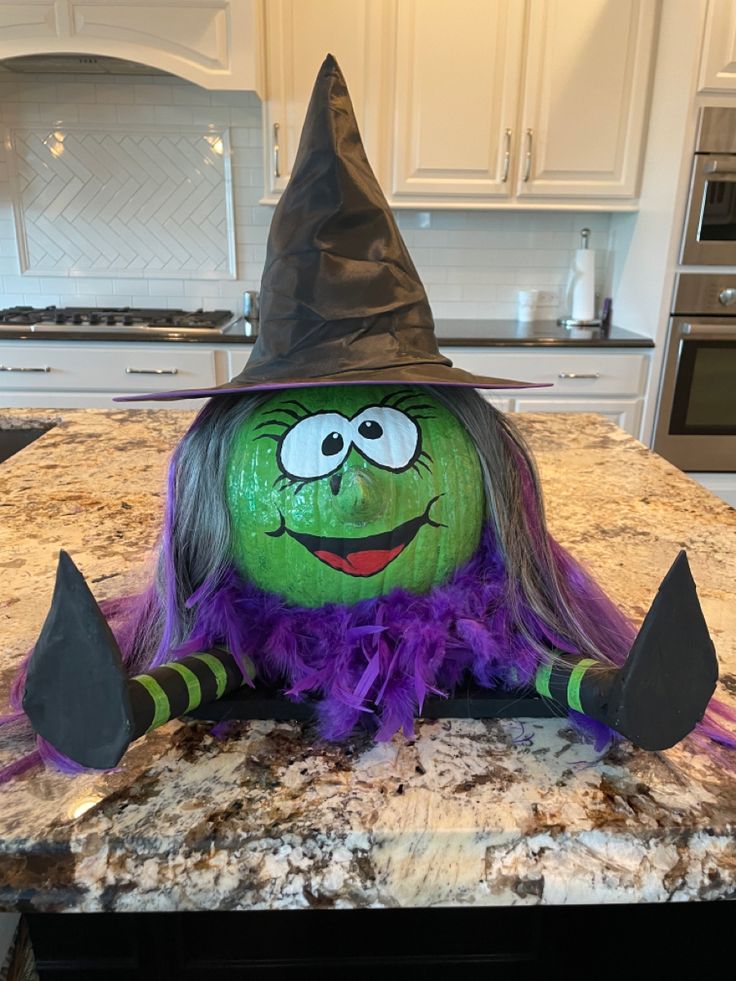 a green and purple witch hat sitting on top of a kitchen counter