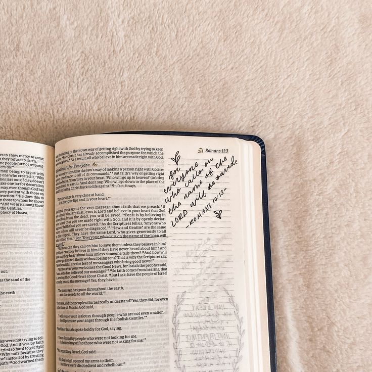 an open book with writing on it sitting on top of a white carpeted floor