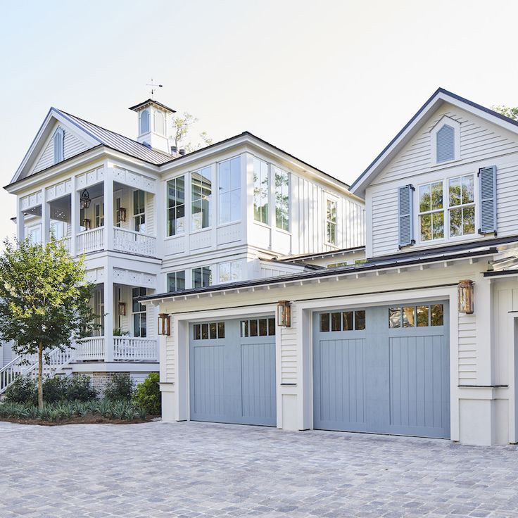 two story white house with blue garage doors