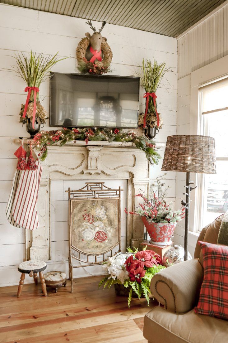 a living room filled with furniture and a fire place covered in wreaths on the mantle