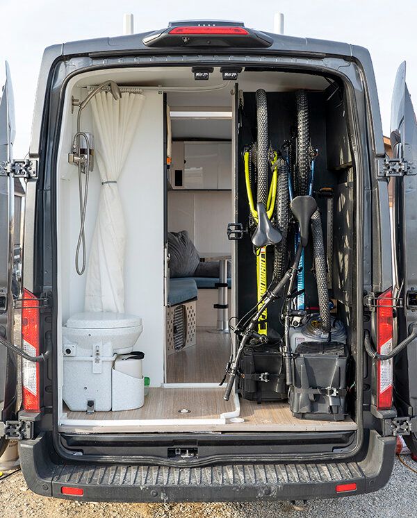 the back end of a van with skis and equipment in it