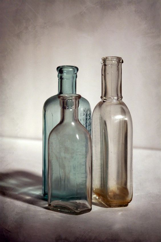 two empty glass bottles sitting next to each other