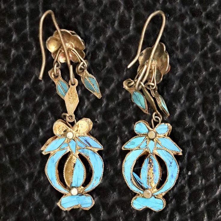 These dangle earrings are antiques that originate from the Qing Dynasty, where a noble woman would have worn an intricate design such as this for a special occasion.Antique stock, made by hand in the late 19th or early 20th century. Gilded silver with kingfisher feather (tian-tsui) finish. 2 inches tall with french hook ear wires. Antique Earrings With Historical Design For Ceremonial Occasions, Ornate Historical Design Earrings, Victorian Style Ceremonial Dangle Earrings, Victorian Style Ceremonial Earrings For Pierced Ears, Victorian Hallmarked Earrings For Ceremonial Occasions, Antique Ceremonial Earrings, Antique Ceremonial Dangle Earrings, Ornate Ceremonial Drop Earrings, Antique Drop Earrings With Historical Design