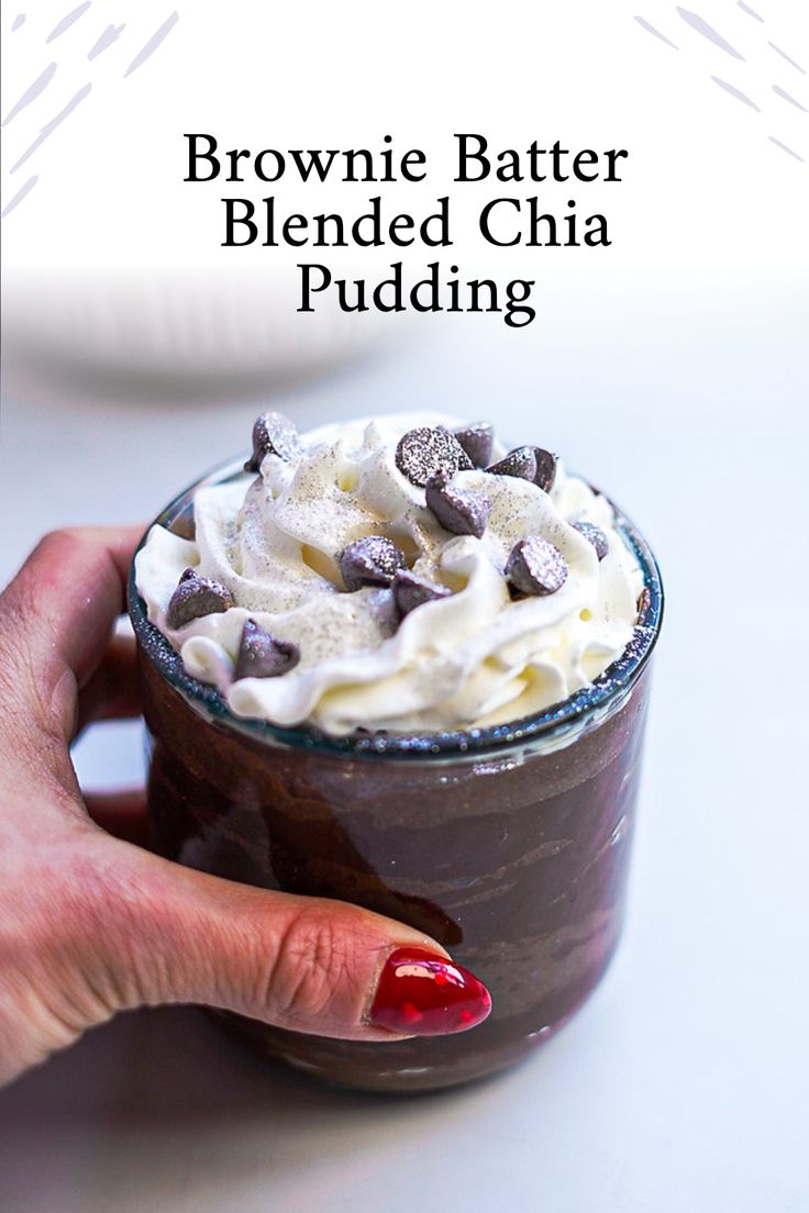 a hand holding a chocolate drink with whipped cream and chocolate chips on top, in front of the caption reads brownie batter blended china pudding