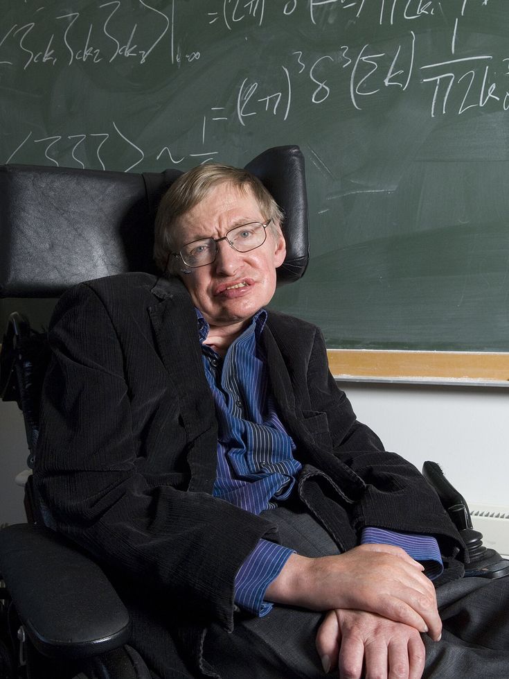 a man sitting in a chair next to a blackboard