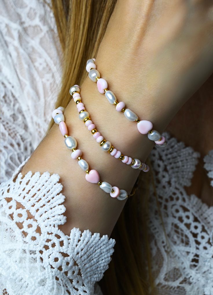 "Gorgeous handmade pink queen conch shell and pearl beaded beach bracelets. Pale pink natural queen conch shell rondelle beads paired with white freshwater pearls and 24k gold plated accent beads on a braided cord with a mother of pearl button closure. Sold individually or by the pair (save when you purchase the pair). Great beach gift for her. Pretty Jasmine Sol gift box included. Beads: 4mm natural pink queen conch shell rondelle, 6mm rondelle pearls in white, 3mm and 4mm 24k gold plated accent beads. Choose Length:  S-6\" M-7\" L-8\" Please measure your wrist to make sure bracelet will fit. Generally you would choose a size that's approximately an inch larger than the circumference of your wrist so it fits comfortably. Photos are close up to show detail. Please refer to measurement info Handmade Pink Pearl Bracelet, Elegant Pink Beaded Bracelets For Beach, Handmade Dainty Pink Pearl Bracelet, Pink Pearl Bracelet Gift, Pink Beaded Bracelet With Pearl Charm As A Gift, Pink Beaded Bracelet With Pearl Charm For Gift, Elegant Pink Bracelets For Beach, Feminine Pink Pearl Bracelet For Gift, Feminine Pink Pearl Bracelets