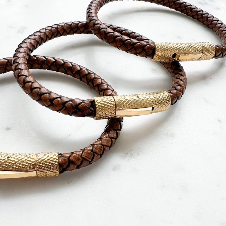 Crafted with braided natural leather and accented with gold stainless steel hardware, our Bourbon Leather Gold Men's Bracelet adds the perfect touch of sophistication to any outfit. The snap closure ensures a secure fit, and with three sizes available, there's a perfect fit for everyone. Elevate your style with this timeless accessory. Comes boxed. Available in three sizes: Small 7.5”, Medium 8.5”, Large 9.25”. Imported. Real Leather. Non toxic design. Gold Leather Bracelets With Gold-tone Hardware, Modern Gold Leather Bracelet With Gold-tone Hardware, Adjustable Gold Leather Bracelet With Gold-tone Hardware, Adjustable Leather Bracelets With Gold-tone Hardware, Gold Leather Bracelet With Brass Hardware, Luxury Brown Leather Everyday Bracelet, Adjustable Leather Bracelet With Gold Clasp, Modern Braided Leather Bracelets, Everyday Braided Leather Bracelets