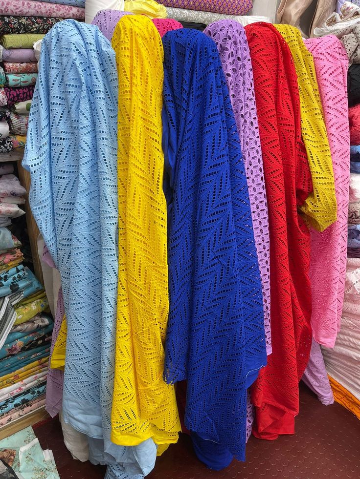 there are many different colored sweaters on display in the store, including one blue and one yellow