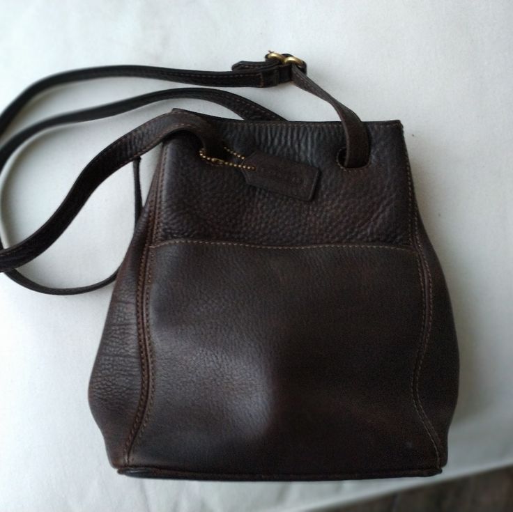 *Material: Leather-Chocolate Brown. * Size: Medium * Measurements (L X H X W): 7" X 10.5" X 5" *Width - 8" *Depth - 5" *Strap Drop - 22" At The Longest * Goldtone Hardware * Coach Leather Hangtag * Outside Front And Back Slip Pockets * Magnetic Snap Closure * Black Fabric Lining Inside * Leather Handle * Closure: Drawstring, * Inside Pockets: 1 **Some Wear That Adds To The Distressed Finish Of The Leather. Interior Is In Mint Condition! ***See Photos. Functional, Cool, On Trend Bag. Absolutely A Trend Bag, Vintage Coach Bags, Bags Coach, Black Crossbody, Coach Bag, Bead Leather, Deep Teal, Bag Style, Coach Leather