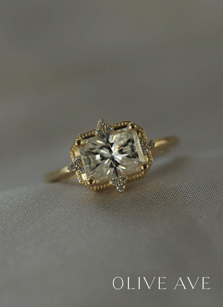 a yellow gold ring with an oval cut diamond in the center