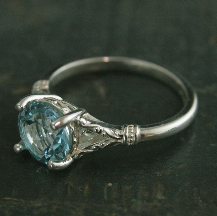 Sky Blue Topaz Ring Elsa Ring 8mm Blue Topaz Split Shank Solitaire Scroll Design Arendelle Inspired Ring March Birthstone Ring Gift for Her Our New Elsa design features an elegant split prong solitaire setting holding a large 8mm Genuine Sky Blue Topaz. The delicate scroll design on each flange of the shank races up to meet the sturdy four pronged basket setting. The basket also features a raised design to compliment the shank. The stone sits approximately 6mm off your finger. The shank measures Turquoise Topaz Ring With Center Aquamarine Stone, Heirloom White Topaz Ring In Round Shape, Turquoise Blue Topaz Ring With Center Stone, Classic Topaz Ring With Gemstone Accents For Promise, Exquisite Blue Topaz Ring For Anniversary, Elegant Turquoise Jewelry With Center Stone, Exquisite Aquamarine Wedding Jewelry, Heirloom Aquamarine Jewelry With Center Stone, Classic Blue Topaz Promise Jewelry