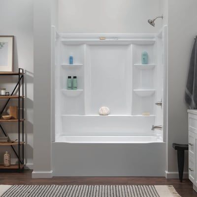 a white bath tub sitting inside of a bathroom next to a shower head and shelves