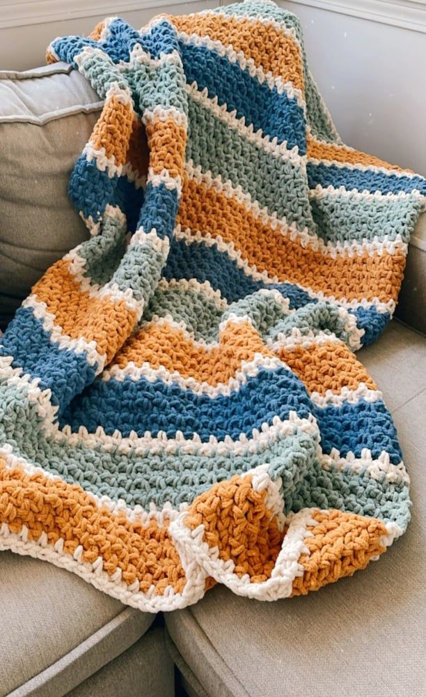 a crocheted blanket sitting on top of a couch