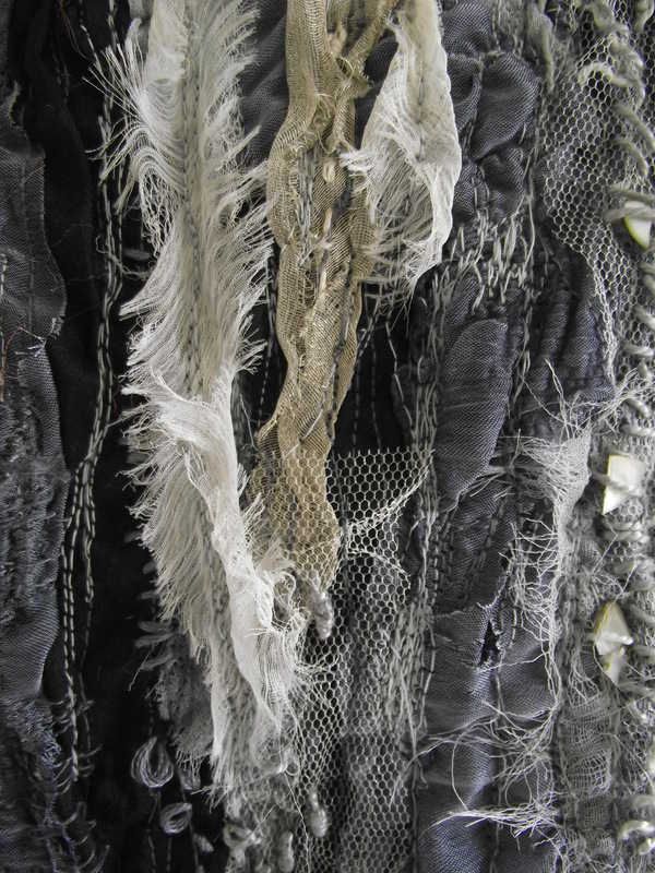 there are many pieces of black fabric with white feathers hanging from the top and bottom