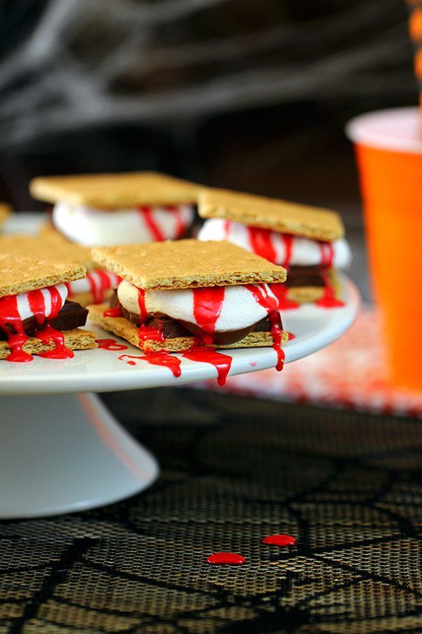 desserts are arranged on a cake stand with red and white icing drizzled around them