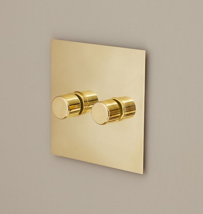 two gold - plated lights are mounted on the wall