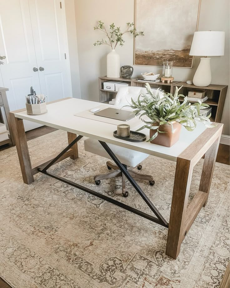 a desk with a laptop on top of it in front of a white door and rug