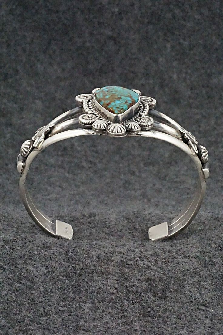 This stunning Kingman turquoise and sterling silver bracelet was made by Navajo silversmith Rosita Calladitto. The back is signed R Calladitto and stamped Sterling.Size: 5 5/8" (will fit up to a 6 3/4" wrist)Gap: 1 1/8"Width: 1 5/8"Cuff Width: 1/2"Free shipping on all orders! We ship with USPS and always include tracking. All orders ship within a day of payment.Returns are accepted up to 30 days after you receive your order. Just send us a message. Our shop offers cash back or store credit. The Unique Engraved Turquoise Jewelry, Elegant Turquoise Bracelet With Inlay, Unique Turquoise Jewelry With Polished Finish, Elegant Turquoise Inlay Bracelet, Artisan Turquoise Sterling Silver Bracelet, Elegant Engraved Turquoise Sterling Silver Bracelet, Elegant Turquoise Engraved Sterling Silver Bracelet, Western Style Bangle Jewelry Gift, Western Style Bangle Jewelry As Gift