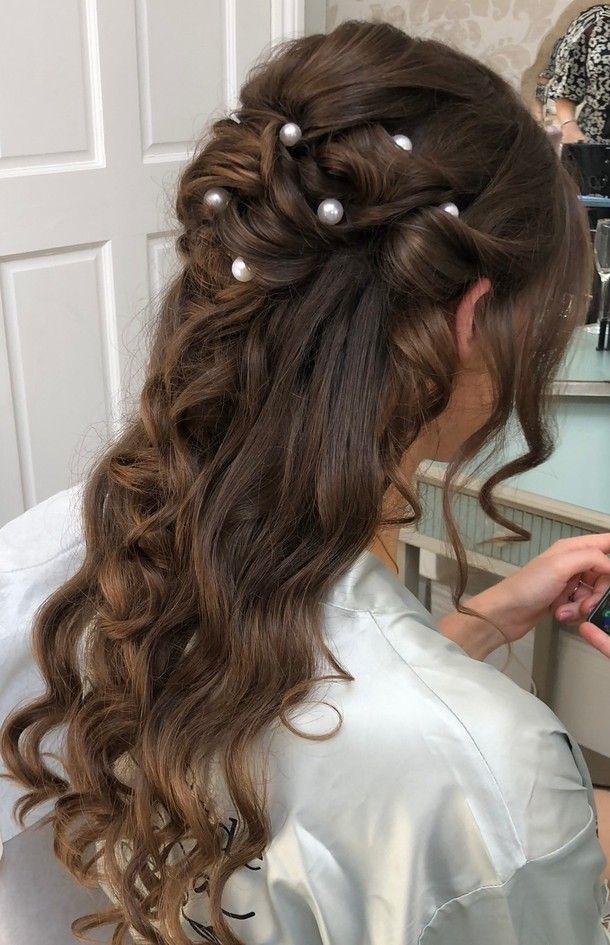 a woman is getting her hair done with pearls