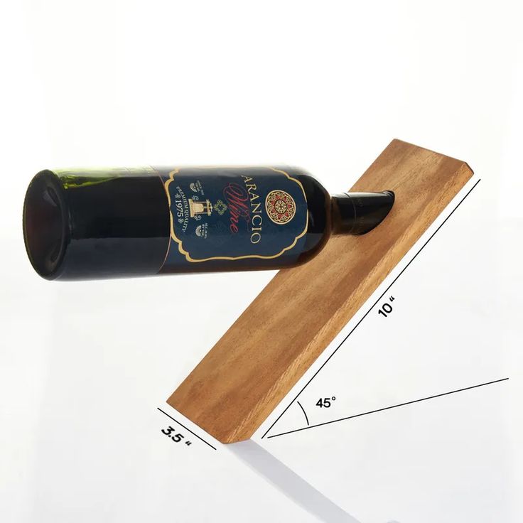 a bottle of wine sitting on top of a wooden board next to a measuring ruler