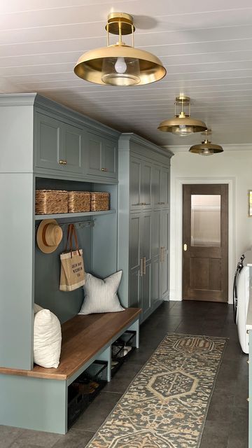 a hallway with blue cabinets and baskets on the shelves, an area rug in front of it