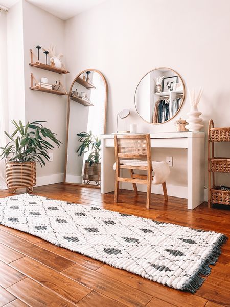 a living room with wooden floors and white walls, including a rug on the floor