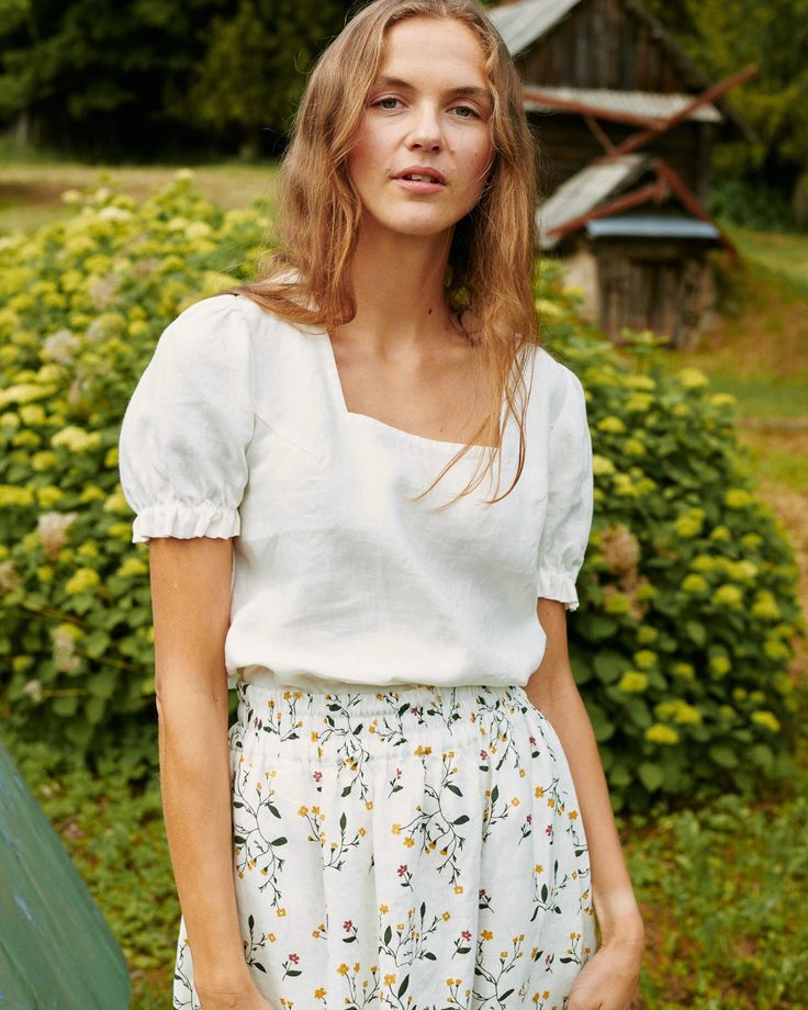 Puff sleeve top with a subtle trapeze neckline. A gentle, a-line, trapeze shape that floats subtly away from the body. Mid armhole darts. Looks gorgeous tucked or un-tucked. We love pairing it with any of our skirts and pants. Model is wearing a top in cream, paired with SION skirt in sunny field. Summer Top With Smocked Bodice For Garden Party, Summer Garden Party Top With Smocked Bodice, Chic Short Sleeve Peasant Top With Smocked Back, Spring Short Sleeve Peasant Top With Gathered Sleeves, Summer Short Sleeve Peasant Top With Gathered Sleeves, Linen Tops With Square Neck For Day Out, Square Neck Linen Tops For Day Out, Chic Blouse With Gathered Neckline For Spring, Summer Tops With Gathered Sleeves, Flowy Fit