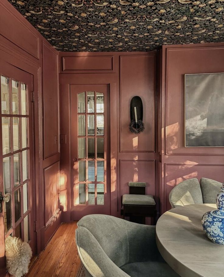 a living room filled with furniture and walls covered in wallpapered coverings next to a wooden floor