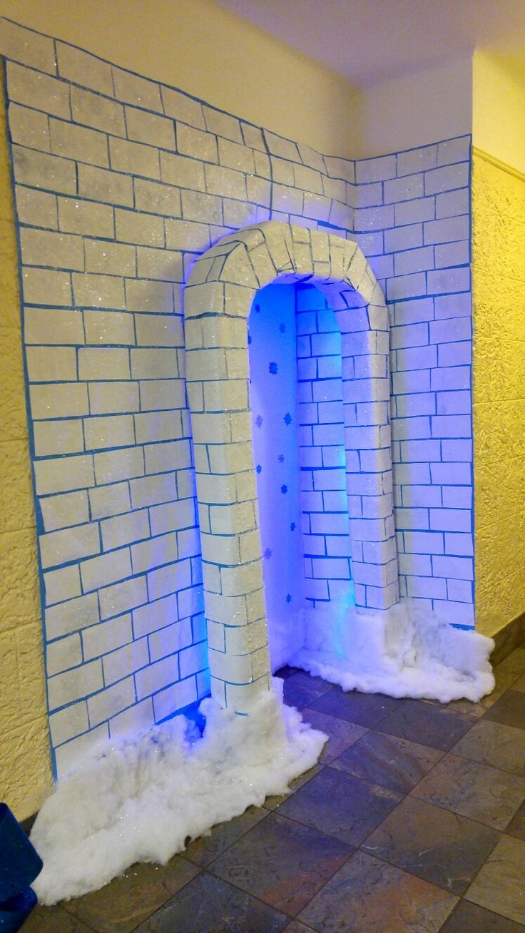 a room that has some snow on the ground in front of it and an archway