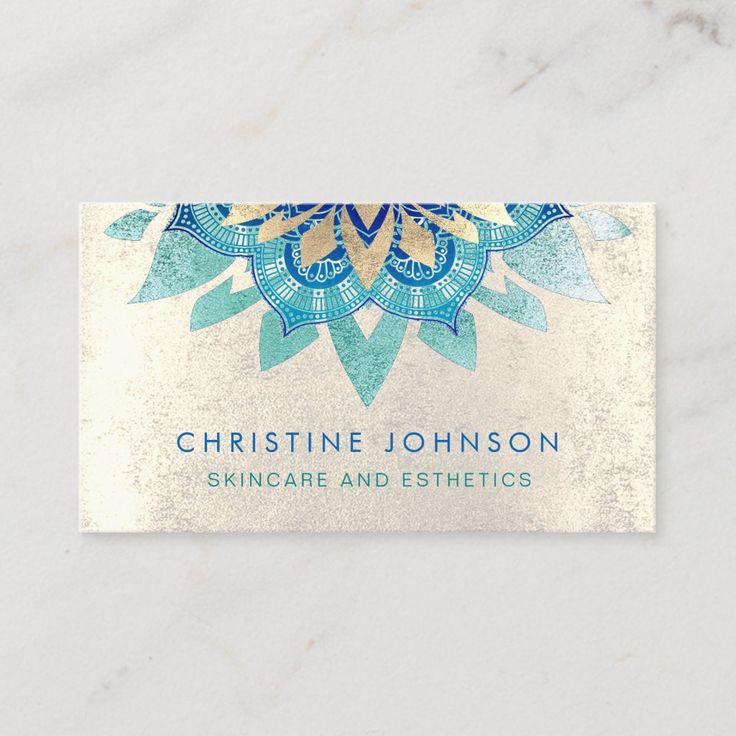 a business card with an ornate design on the front and bottom, featuring blue flowers