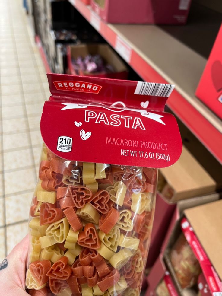 someone holding up a bag of pasta in a store