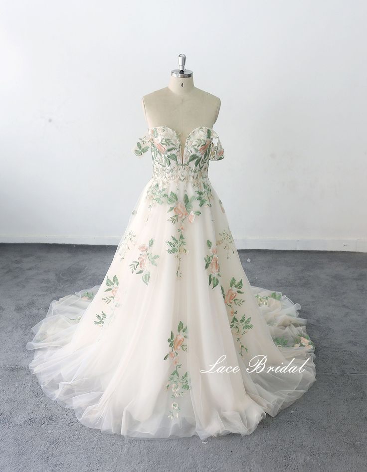 a white wedding dress with flowers on it