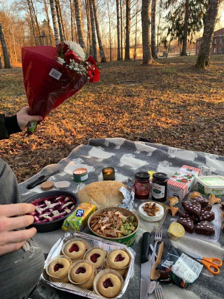 a person sitting at a picnic table with food on it