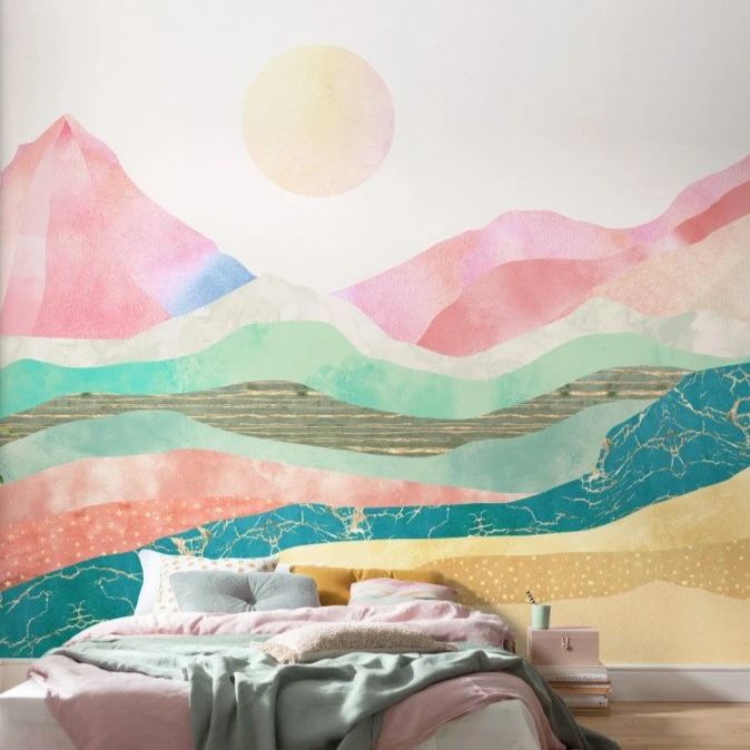 a bed sitting under a painting on the side of a wall next to a wooden floor