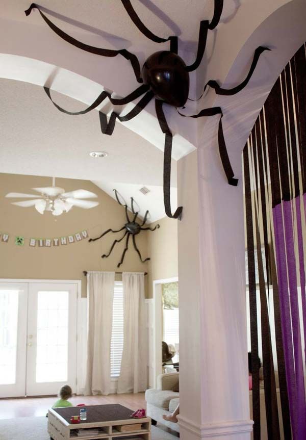 a spider hanging from the ceiling in a living room