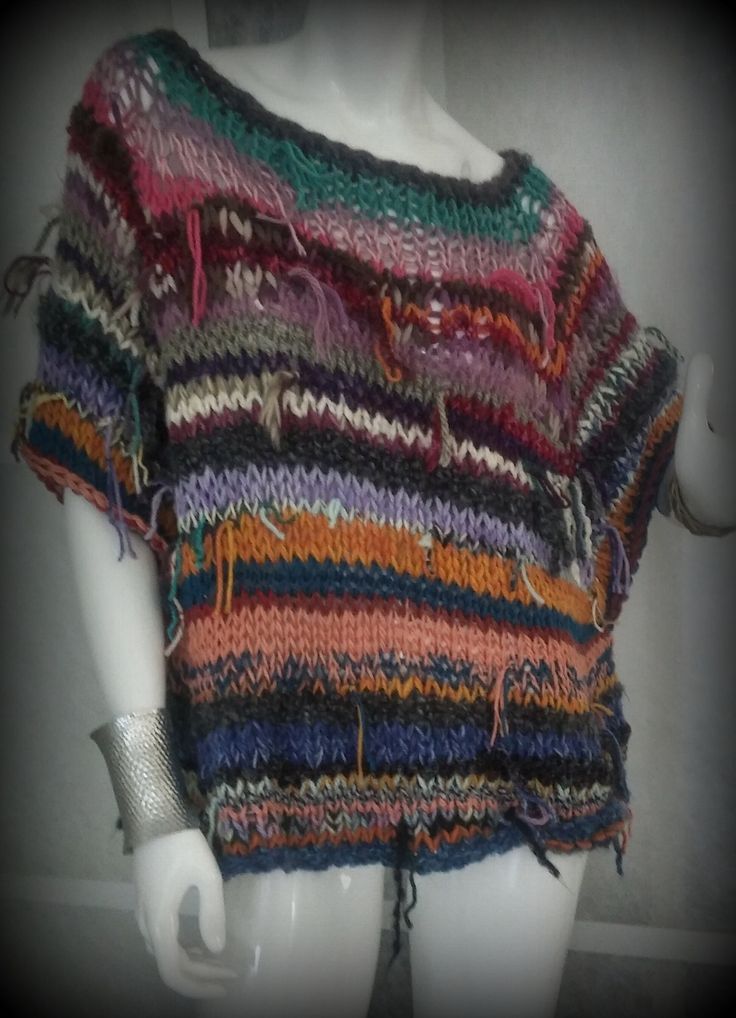 a white mannequin wearing a multicolored sweater