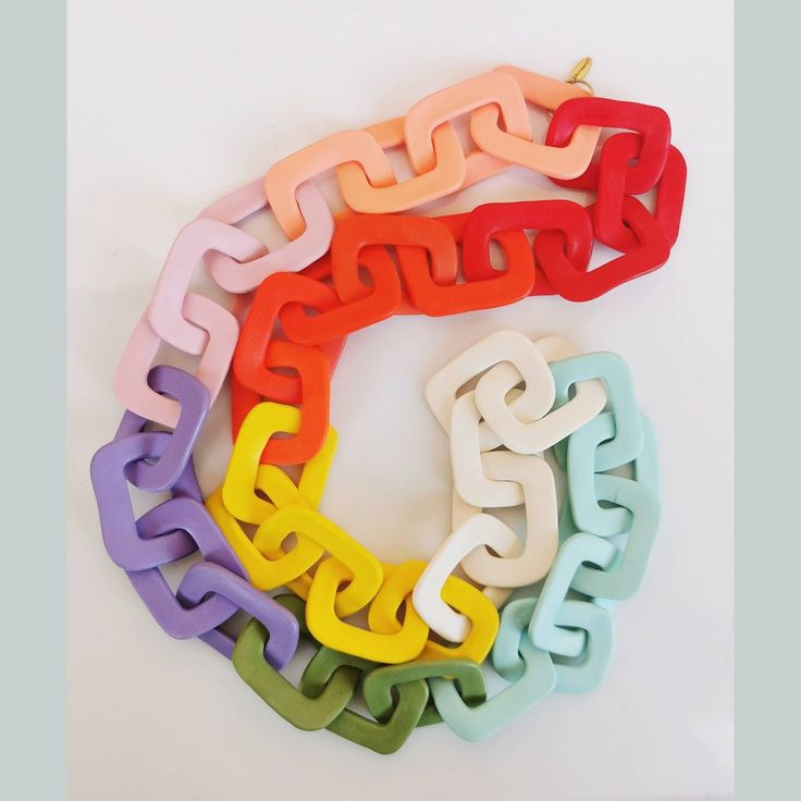 four different colored plastic chains on a white surface