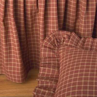 red and white checkered bedding with ruffles on the bottom, in front of a wooden floor