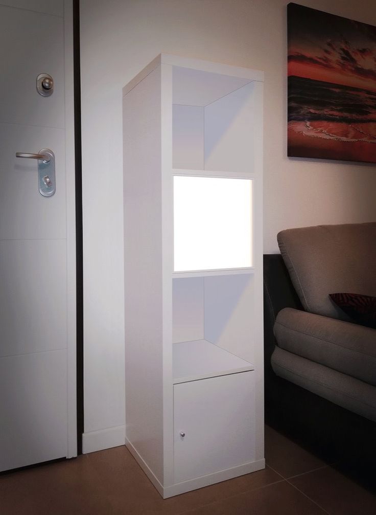 a white book shelf sitting next to a couch