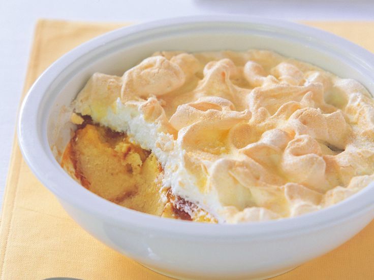 a white bowl filled with food on top of a yellow table cloth next to a fork