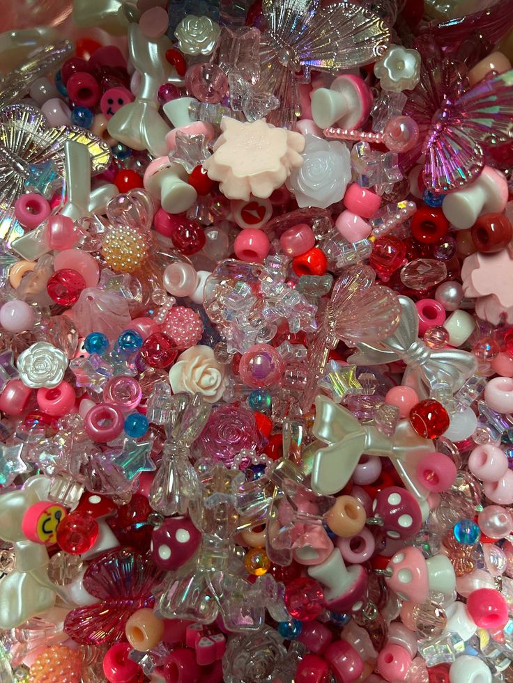 there are many different types of buttons in the pile together on this table, including pinks and whites