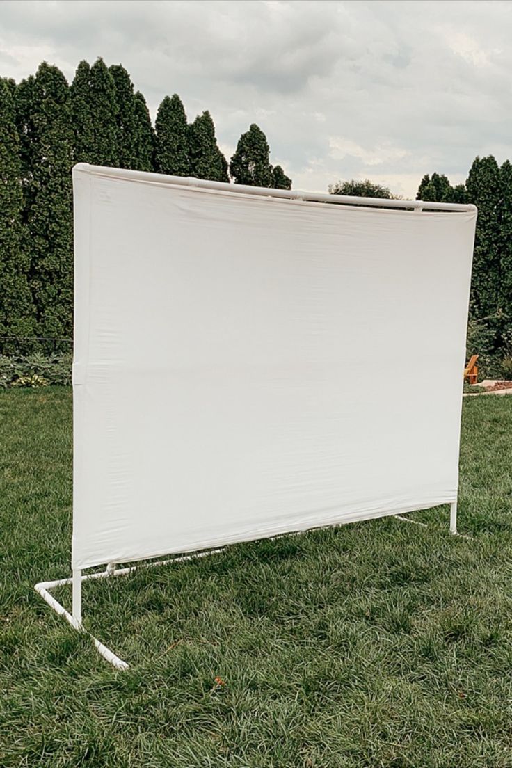 an empty white screen in the middle of a grassy field