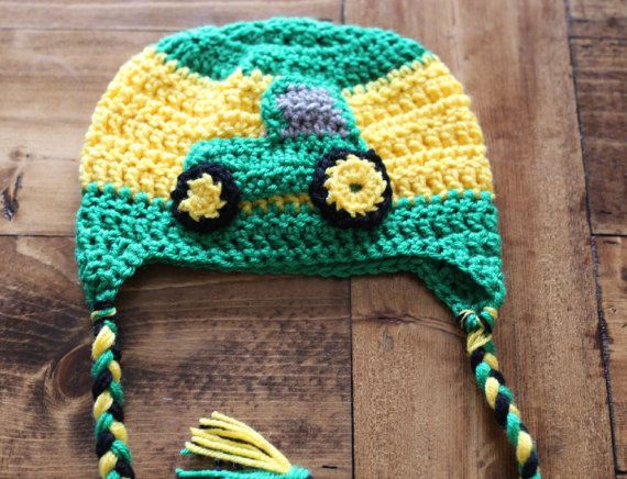 a crocheted hat with yellow and green trim on top of a wooden floor