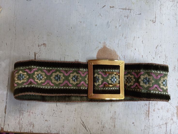 Brown, green and purple old belt with beautiful buckle. A hole on the belt no other flaws.  Length 58cm Folded 28cm Buckle 9*9cm Vintage Belt With Antique Buckle, Vintage Belts With Rectangular Antique Buckle, Vintage Brown Embroidered Belt, Vintage Brown Belt As A Gift, Vintage Brown Belt As Gift, Vintage Brown Belt For Gift, Vintage Handmade Brown Belt, Vintage Belts With Antique Buckle, Adjustable, Vintage Belts And Suspenders With Antique Buckle