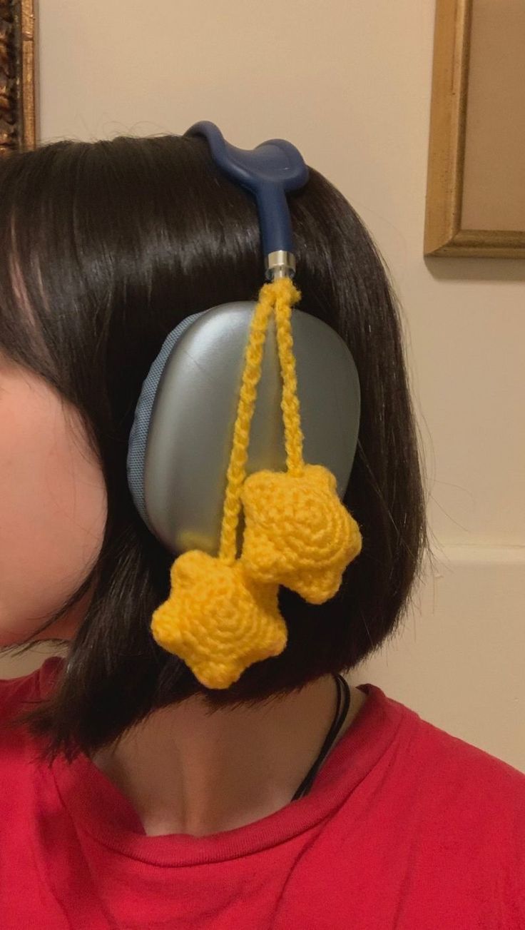 a woman with black hair wearing headphones made to look like pacifiers hanging from her ear